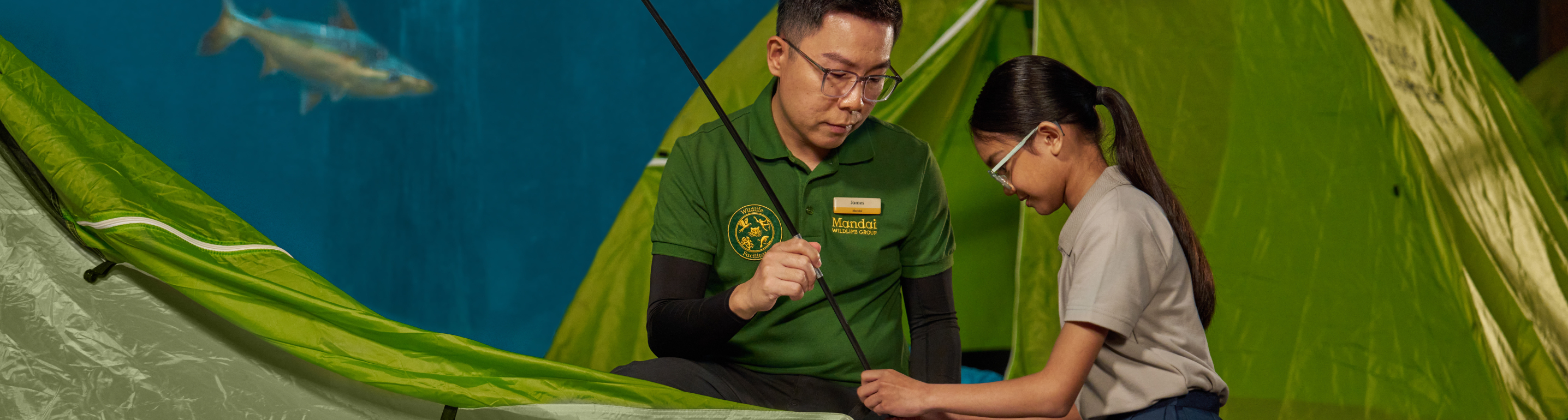 Educator and student looking at a map near a tent