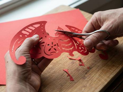 a person cutting paper animal